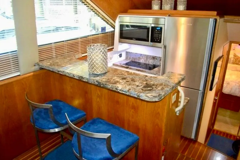 Slide: The Image of 1995 Hatteras 39 Convertible yacht interior with modern kitchen and seating area. - 4