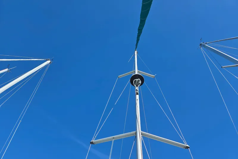 Slide: The Image of Masts of a 2004 Beneteau Oceanis 393 sailboat against a clear blue sky. - 7