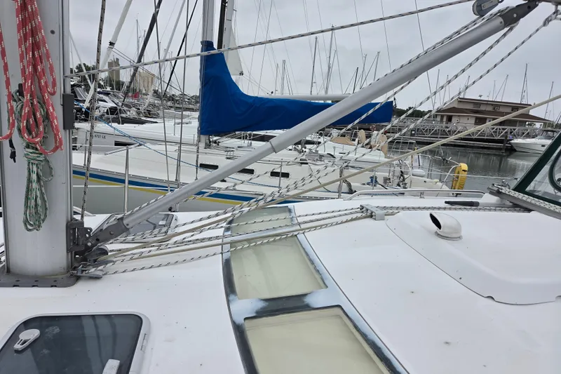 Slide: The Image of 2004 Beneteau Oceanis 393 sailboat docked in a marina, showcasing deck and rigging. - 10