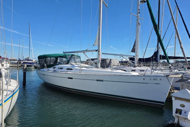 The Image of 2004 Beneteau Oceanis 393 sailboat docked in a marina under clear blue skies. - 0