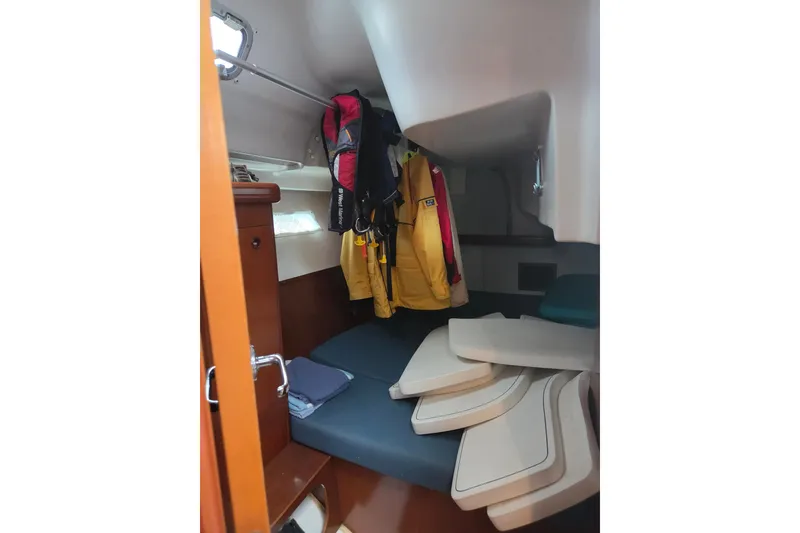 Slide: The Image of Interior cabin of 2004 Beneteau Oceanis 393 sailboat with hanging jackets and cushions. - 16