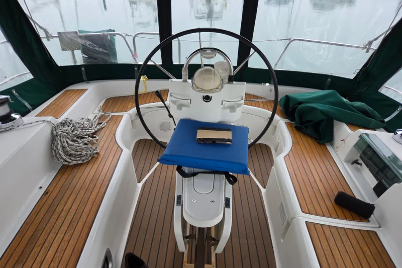Slide: The Image of Cockpit of 2004 Beneteau Oceanis 393 sailboat with wooden flooring and steering wheel. - 8
