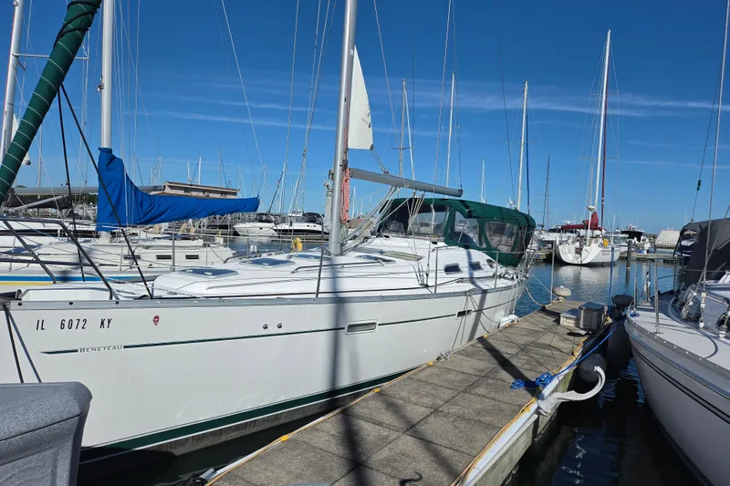 Slide: The Image of 2004 Beneteau Oceanis 393 sailboat docked at a marina under clear blue skies. - 3