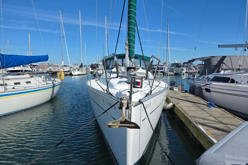 Slide: The Image of Beneteau Oceanis 393 sailboat docked in marina, 2004 model, surrounded by other boats. - 1