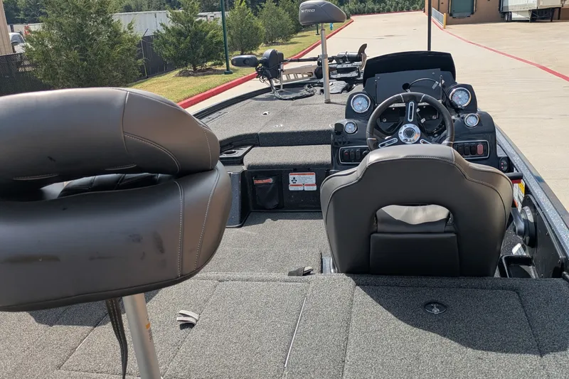 Slide: The Image of 2019 Nitro Z18 boat interior with steering wheel and seating, parked outdoors. - 11