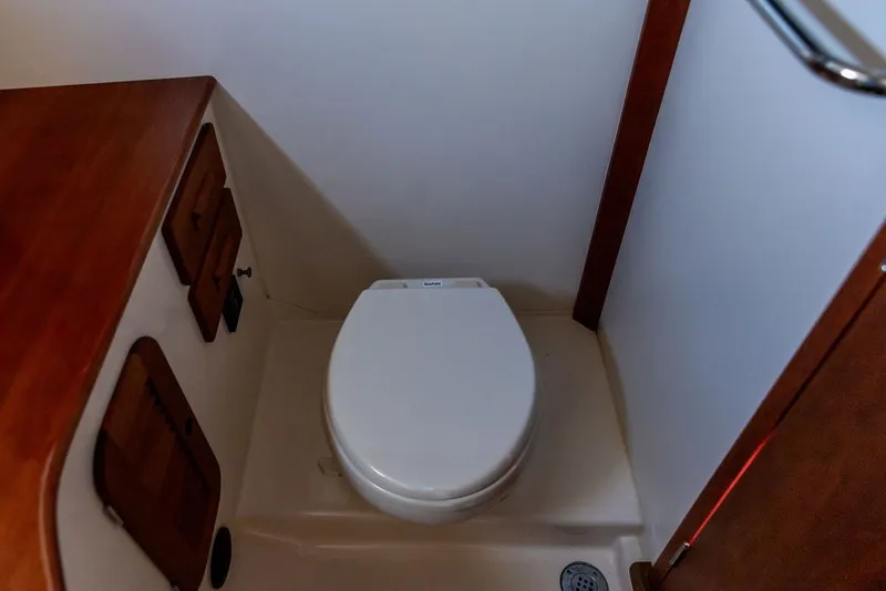 Slide: The Image of 2017 Hinckley Picnic Boat 37 MKIII bathroom with wooden cabinetry and marine toilet. - 17