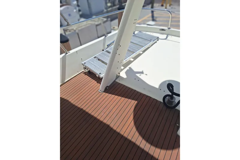 Slide: The Image of 1988 Birchwood 44TS yacht deck with wooden flooring and metal railing. - 16