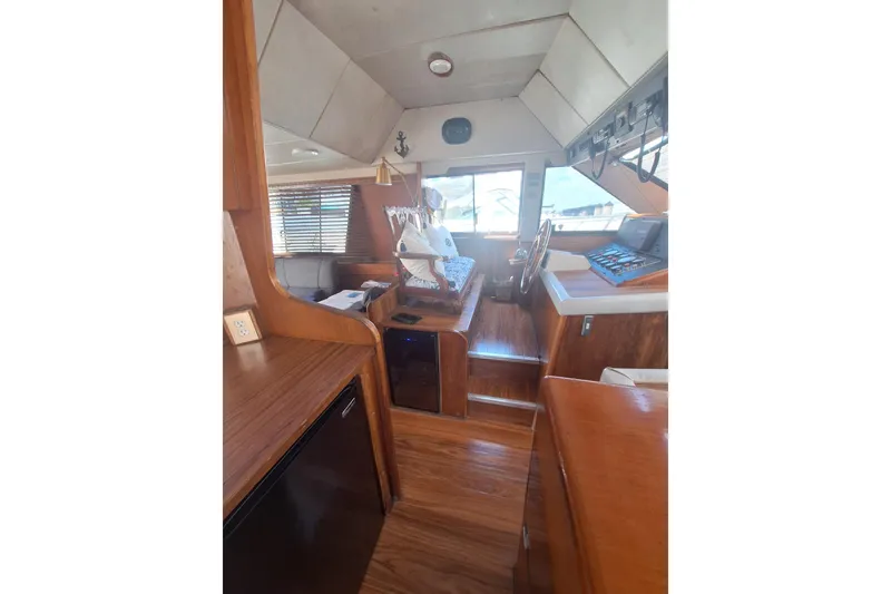 Slide: The Image of Interior of 1988 Birchwood 44TS yacht with wooden finishes and navigation controls. - 21