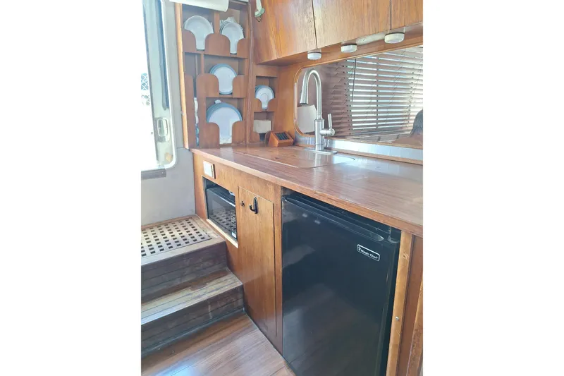 Slide: The Image of Vintage 1988 Birchwood 44TS yacht kitchen with wooden cabinetry and compact appliances. - 39