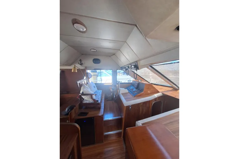 Slide: The Image of Interior of 1988 Birchwood 44TS boat with wooden helm and seating area. - 29