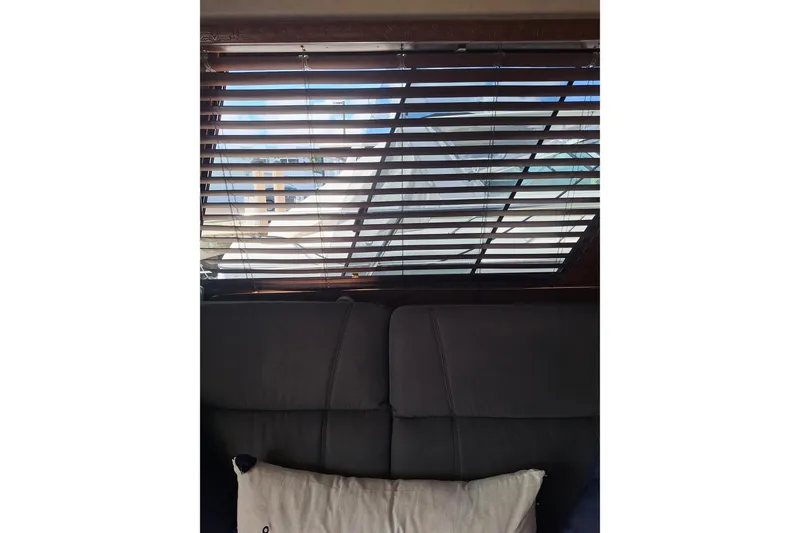Slide: The Image of Interior view of a 1988 Birchwood 44TS yacht with blinds and a cushion. - 41