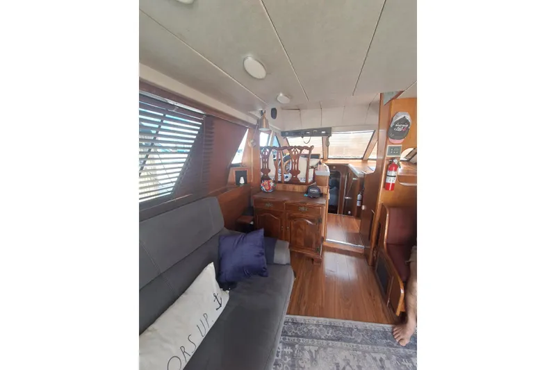Slide: The Image of Interior of 1988 Birchwood 44TS yacht with wooden furnishings and cozy seating area. - 27