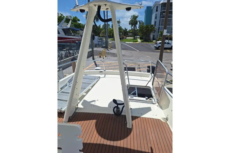 Slide: The Image of 1988 Birchwood 44TS boat deck with open hatch, docked near buildings and parked cars. - 15