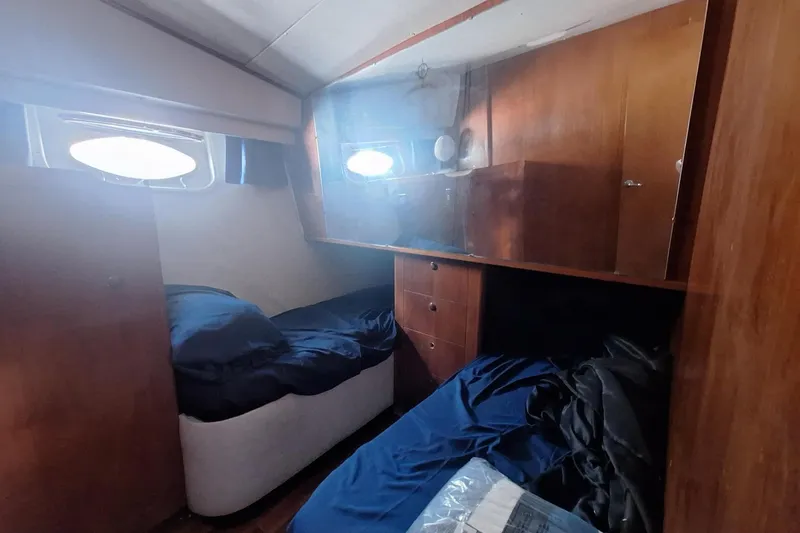 Slide: The Image of Cozy cabin interior of 1988 Birchwood 44TS yacht with wooden furnishings and twin beds. - 34