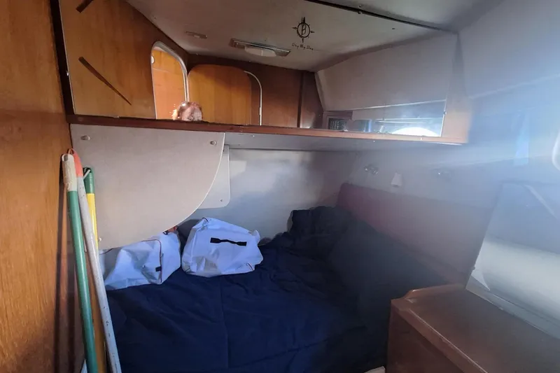 Slide: The Image of Cozy cabin interior of 1988 Birchwood 44TS boat with bed and storage. - 33