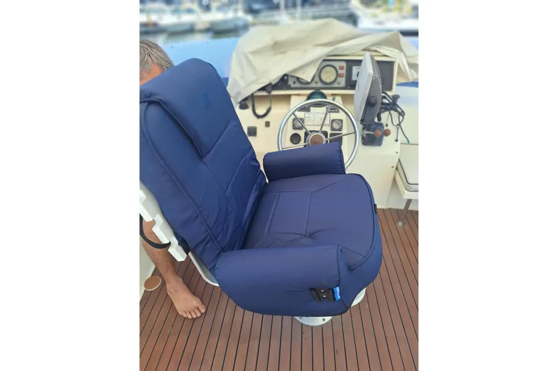 Slide: The Image of Blue captain's chair on 1988 Birchwood 44TS yacht, with steering wheel and dashboard in view. - 13