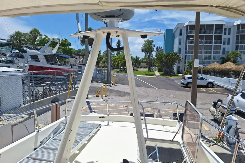 Slide: The Image of 1988 Birchwood 44TS boat docked near marina with parked cars and buildings in background. - 14