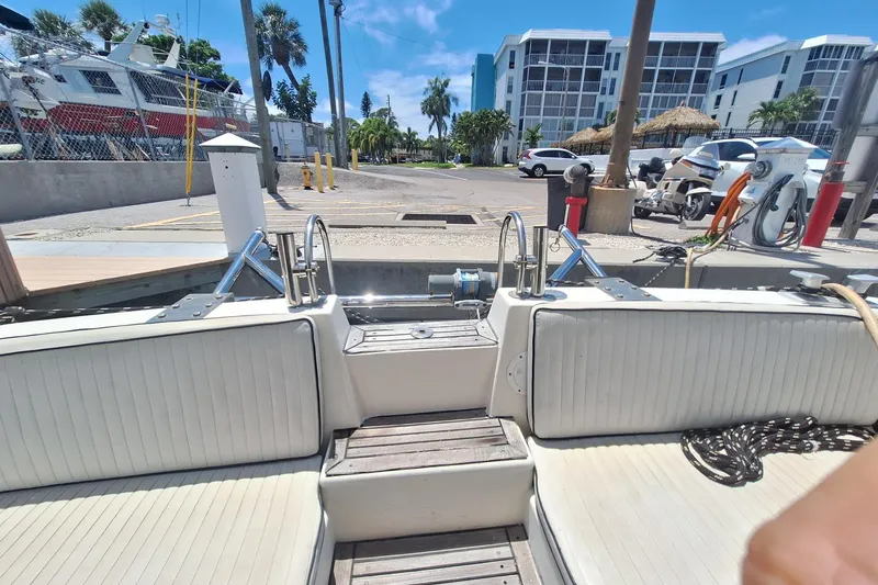 Slide: The Image of 1988 Birchwood 44TS yacht interior with white seating, docked near modern buildings. - 25