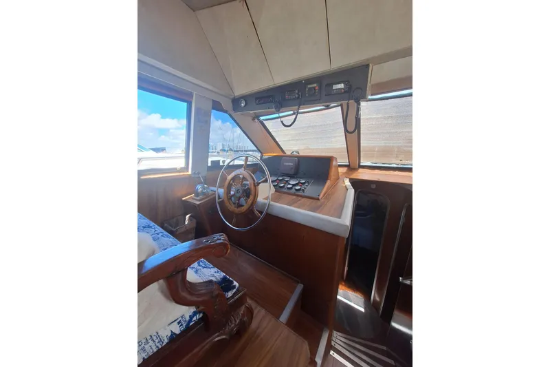 Slide: The Image of Interior of 1988 Birchwood 44TS boat with wooden steering wheel and control panel. - 17