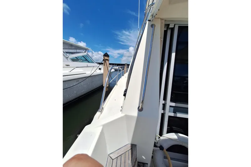Slide: The Image of 1988 Birchwood 44TS yacht docked under a clear blue sky. - 36