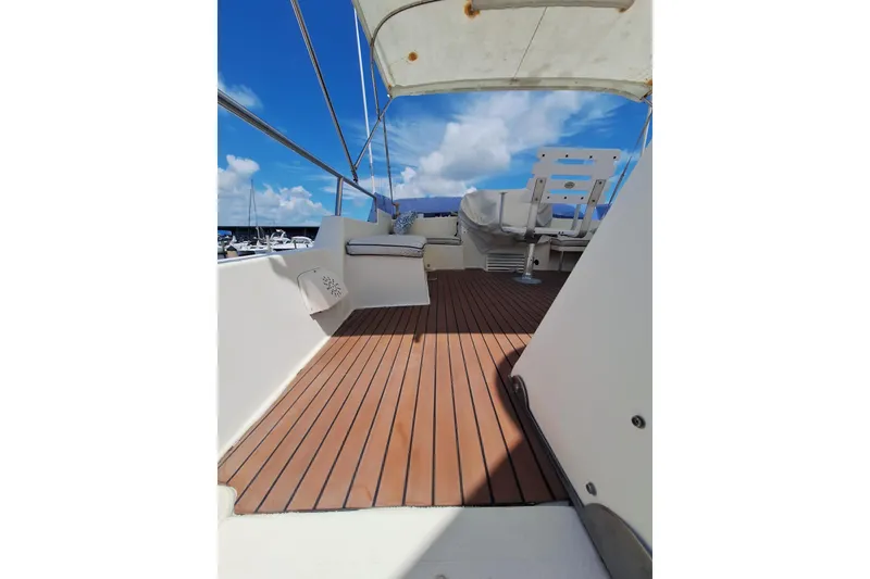 Slide: The Image of 1988 Birchwood 44TS yacht deck with seating, under a clear blue sky. - 37