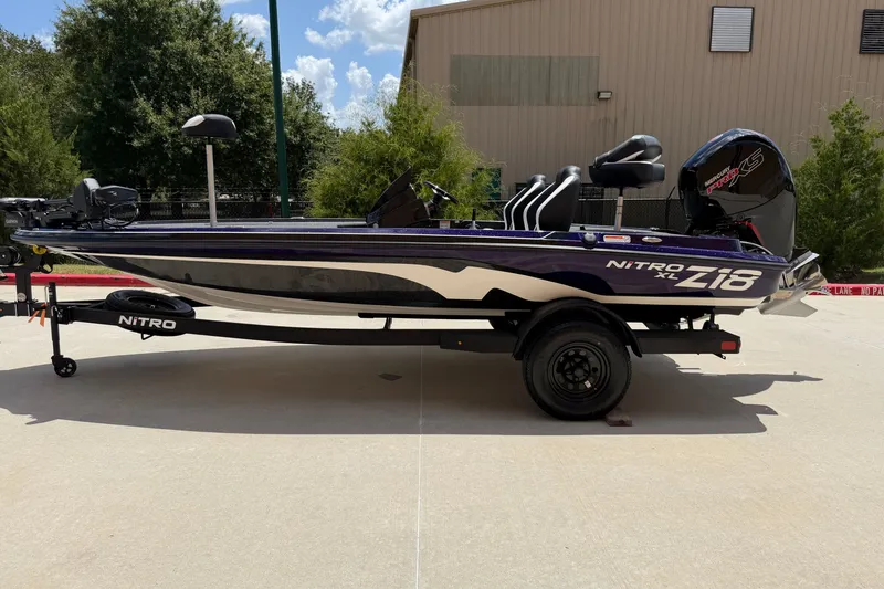 Slide: The Image of 2025 Tracker Pro Team 175 TXW boat on trailer, parked outdoors. - 14