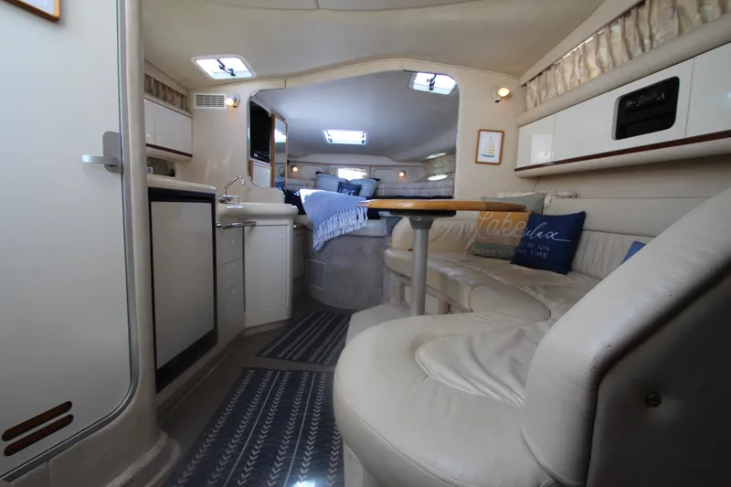 Slide: The Image of Interior of a 1996 Sea Ray Sundancer 330 yacht, featuring a cozy seating area and kitchenette. - 21