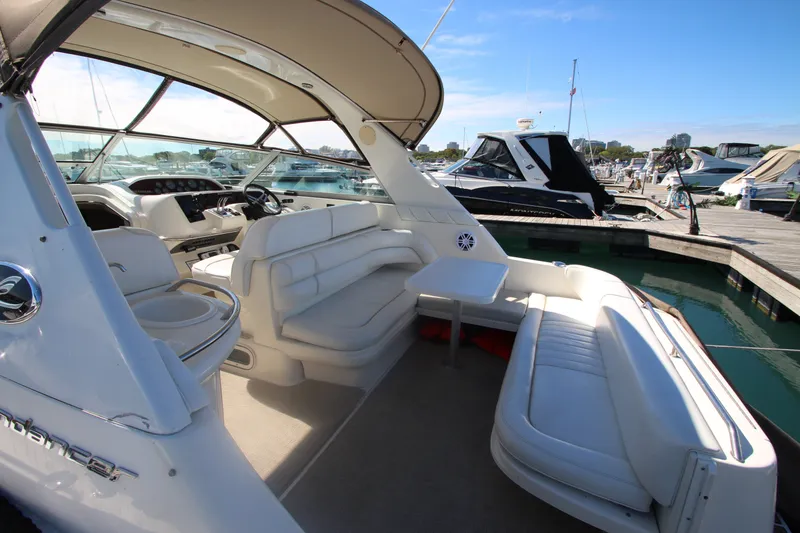 Slide: The Image of 1996 Sea Ray Sundancer 330 yacht interior with white seating and helm, docked at marina. - 6