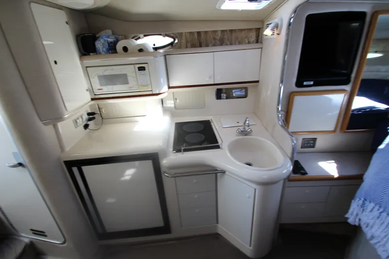 Slide: The Image of Compact kitchen area in a 1996 Sea Ray Sundancer 330 yacht, featuring a sink and microwave. - 24