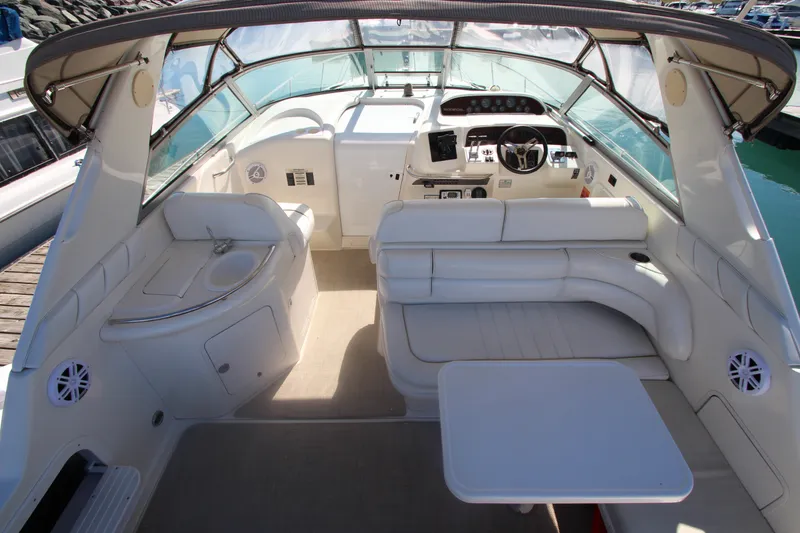Slide: The Image of 1996 Sea Ray Sundancer 330 interior with white seating, helm, and table. - 12