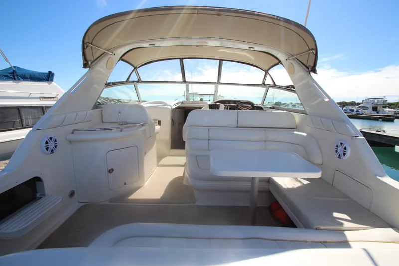 Slide: The Image of 1996 Sea Ray Sundancer 330 interior with seating and table, docked at marina. - 4