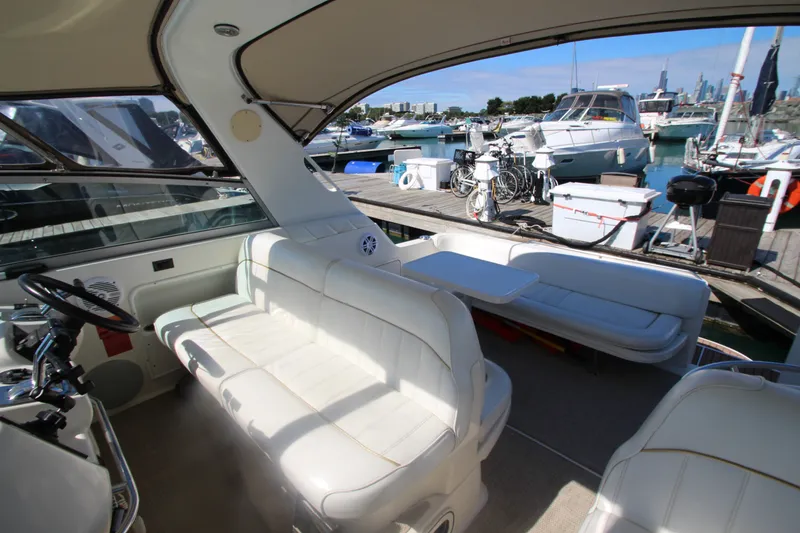Slide: The Image of 1996 Sea Ray Sundancer 330 interior with white seating, docked at marina. - 16