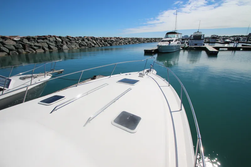 Slide: The Image of 1996 Sea Ray Sundancer 330 yacht docked in a serene marina under a clear blue sky. - 11