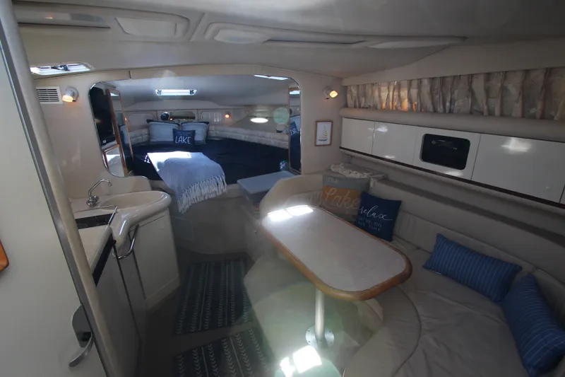 Slide: The Image of Interior of a 1996 Sea Ray Sundancer 330 yacht, featuring cozy seating and a compact kitchen. - 20