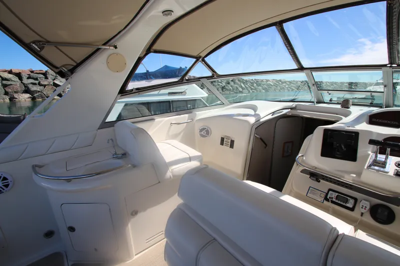 Slide: The Image of Interior view of a 1996 Sea Ray Sundancer 330 yacht, featuring sleek white seating and helm. - 15