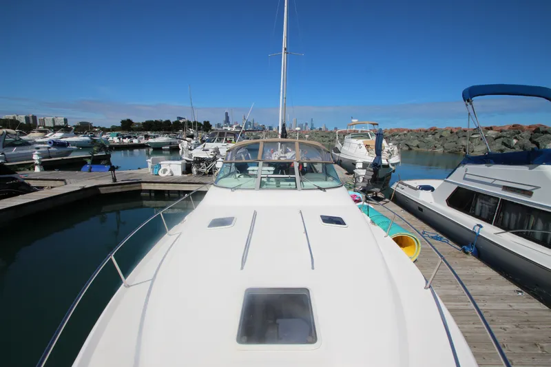 Slide: The Image of 1996 Sea Ray Sundancer 330 docked at a marina with city skyline in background. - 10