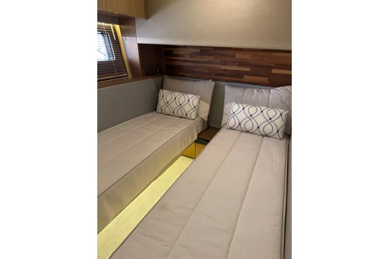 Slide: The Image of 2018 Sea Ray L590 yacht cabin with twin beds and decorative pillows. - 18