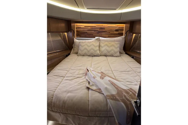 Slide: The Image of Luxurious 2018 Sea Ray L590 yacht bedroom with cozy bedding and elegant wood accents. - 15