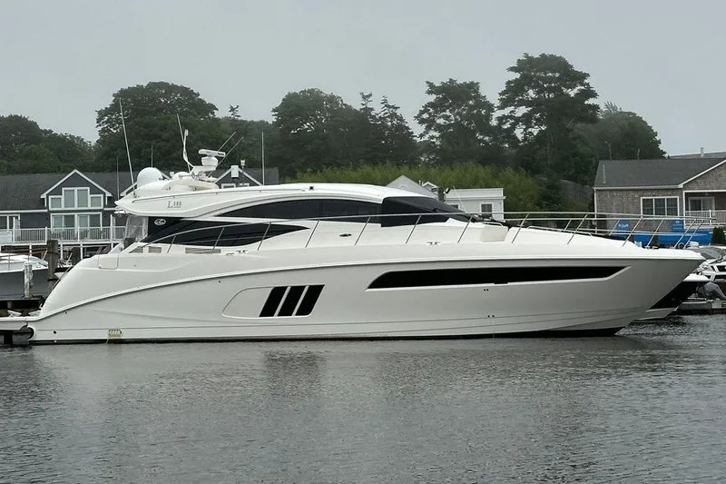 The Image of 2018 Sea Ray L590 yacht docked in a marina with houses in the background. - 0