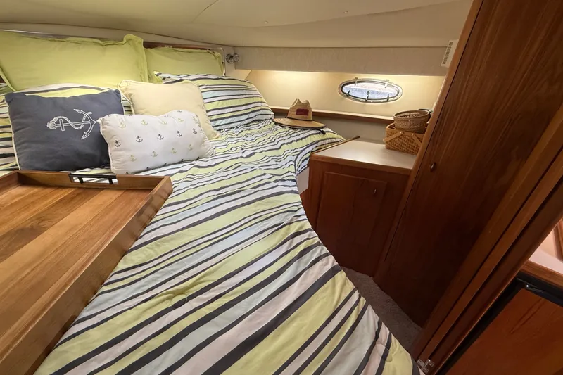 Slide: The Image of Cozy cabin interior of 1997 Tiara 3500 EXPRESS with striped bedding and nautical decor. - 21