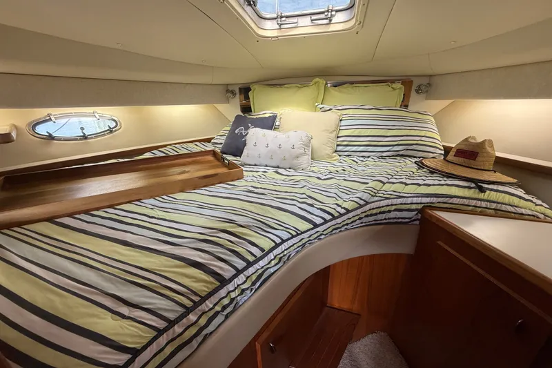 Slide: The Image of Cozy cabin interior of 1997 Tiara 3500 EXPRESS with striped bedding and nautical decor. - 20