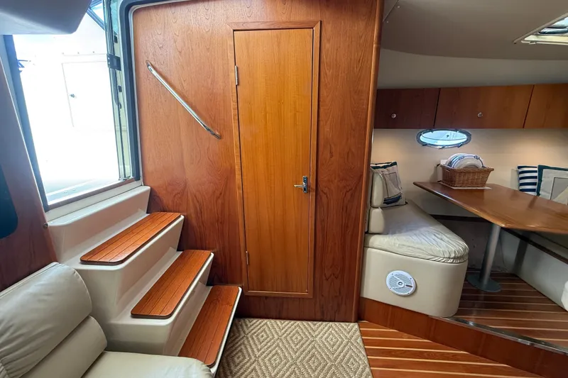 Slide: The Image of Interior of 1997 Tiara 3500 EXPRESS yacht with wooden stairs and cozy seating area. - 15