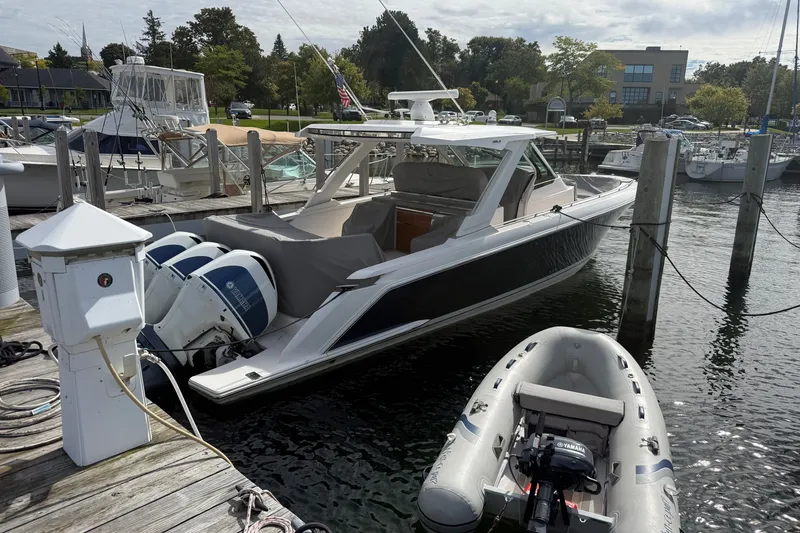 Slide: The Image of 1997 Tiara 3500 EXPRESS boat docked with Yamaha engines, alongside an inflatable dinghy. - 34