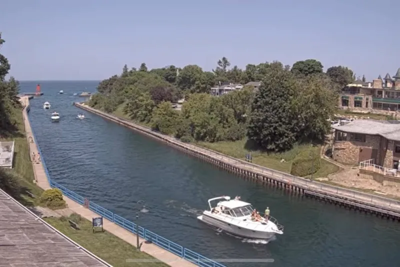 Slide: The Image of Boat navigating a scenic canal with lush greenery and buildings, featuring a 1997 Tiara 3500 EXPRESS. - 35