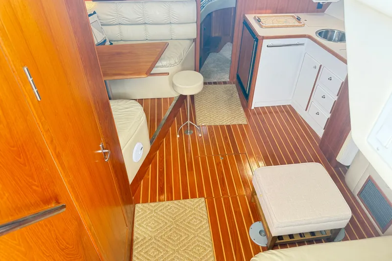 Slide: The Image of Interior of a 1997 Tiara 3500 EXPRESS yacht with wood flooring and cozy seating area. - 13