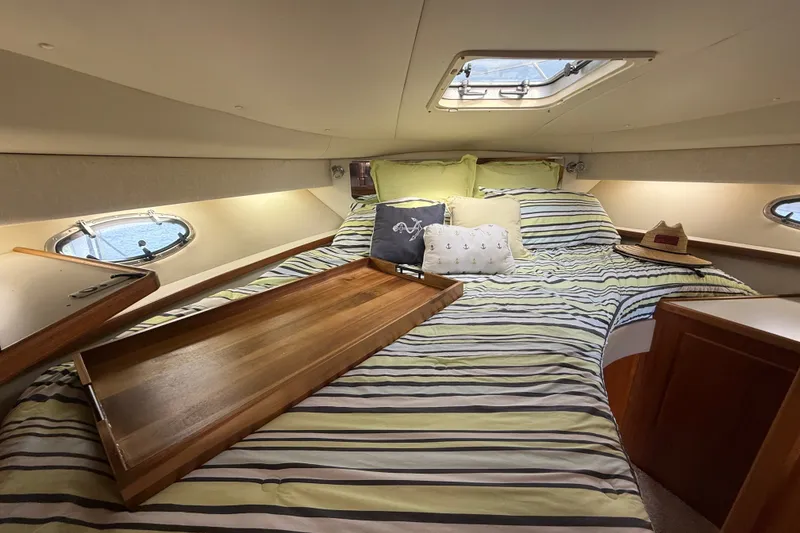 Slide: The Image of Cozy cabin interior of 1997 Tiara 3500 EXPRESS yacht with striped bedding and decorative pillows. - 19