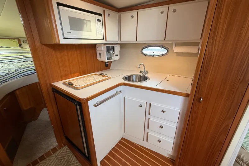Slide: The Image of Compact kitchen area in a 1997 Tiara 3500 EXPRESS boat with microwave and sink. - 18
