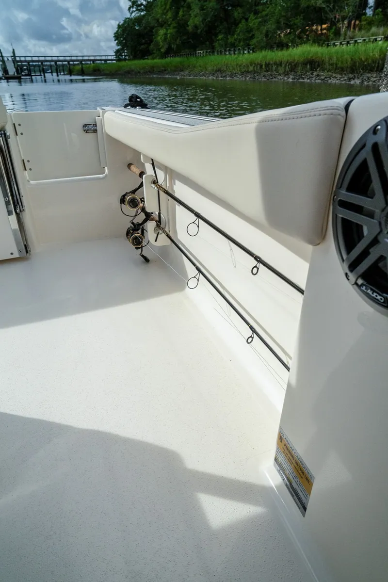 Slide: The Image of Interior view of a Scout 200 Sportfish with fishing rod holders and speaker, docked by the water. - 16