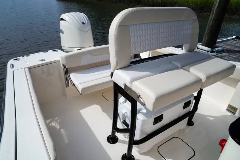 Slide: The Image of The image shows the cockpit of a Scout 200 Sportfish boat with beige seating and an outboard motor. - 25