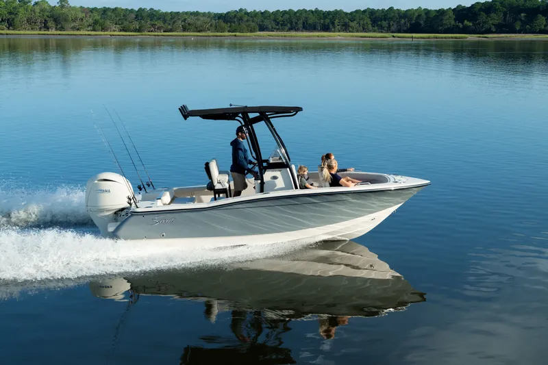 Slide: The Image of A 2027 Scout 200 Sportfish speeds across calm water with three people on board. - 5